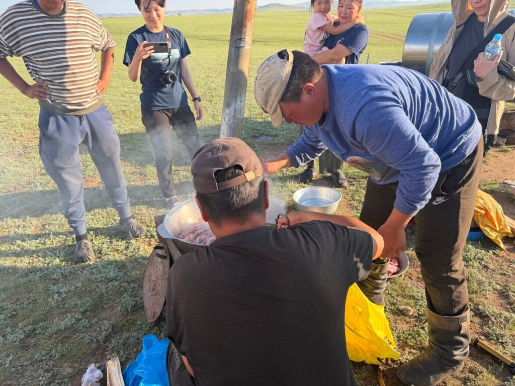湯気の立つ鍋に羊肉を重ねていくところ