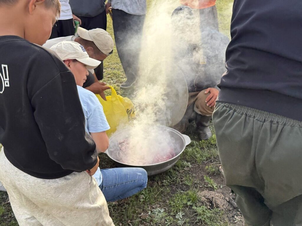 草原で焼いた石と羊肉を鍋に入れるホルホグの準備