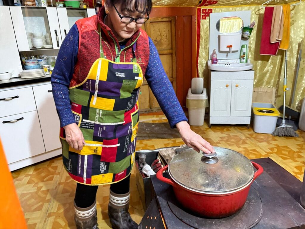 冬のツーリストゲルのキッチンで鍋を火にかけるコックさん